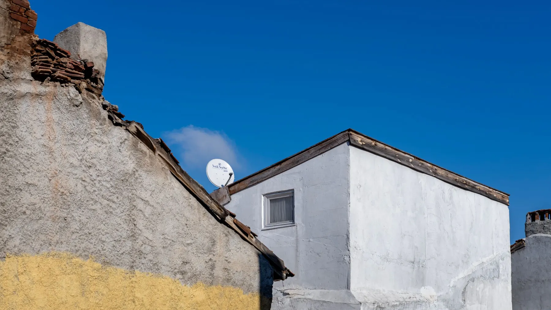 Satellite dish on the gable of a white house